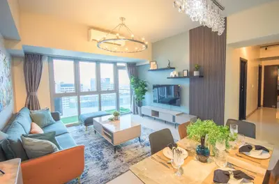 a living room with a blue couch and a table at Luxury 120sqm suite Uptown BGC with spectacular balcony view in Manila