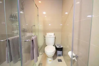 a bathroom with a toilet and a glass shower at Luxury 120sqm suite Uptown BGC with spectacular balcony view in Manila