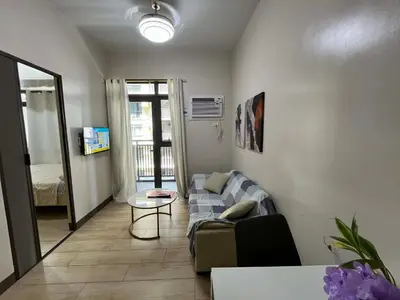 a living room with a couch and a table at GENTRY MANOR fast WiFi,Balcony near Okada,MOA&NAIA 8Q in Manila