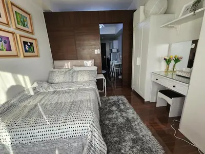 a bedroom with a large bed and a desk at Julie's Place in Manila