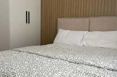a bed with white sheets and pillows on it at Luxa House Staycation Tagaytay in Panungyanan
