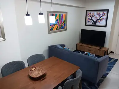 a living room with a blue couch and a table at Smith's Place in Manila
