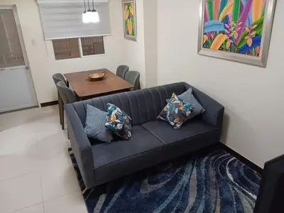a living room with a black couch and a table at Smith's Place in Manila