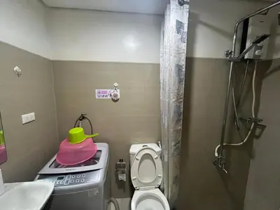 a small bathroom with a toilet and a green hat on a stove at Budget SHORE Family Suite 2 Bed WiFi Netflix MOA844 in Manila
