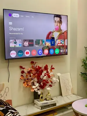 a flat screen tv on a wall with a vase of flowers at Hope Residences by SoCaRi in Trece Martires