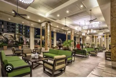 a lobby with green chairs and tables in a restaurant at lea home flair tower staycation mandaluyong in Manila