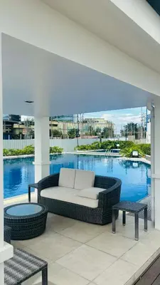 a living room with a couch and tables on a balcony at Prestige Suite at Tulip Gardens Southwoods in Jalang