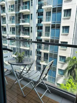 a table and chairs on a balcony with a large building at LDN 5J - Condotel Newport in Manila