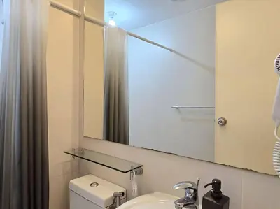a bathroom with a sink and a mirror and a toilet at 1BR Condotel at Azure Urban Resort Near Airport #AZ05 in Manila