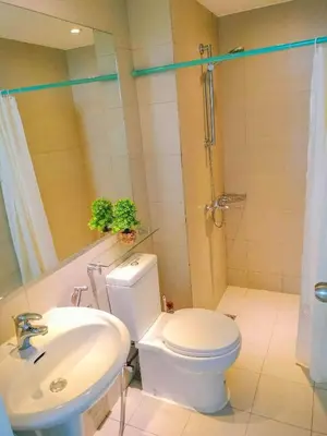 a bathroom with a white toilet and a sink at Cozy 2 Bedroom With Blacony in Manila