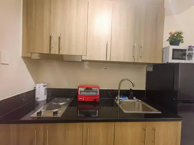 a kitchen with a sink and a red appliance on a counter at 1BR Condotel with Balcony at FAME Residences #FM37 in Manila