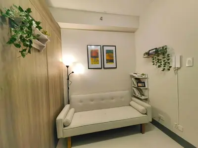 a living room with a bench in a room at 1BR Condotel with Balcony at FAME Residences #FM47 in Manila