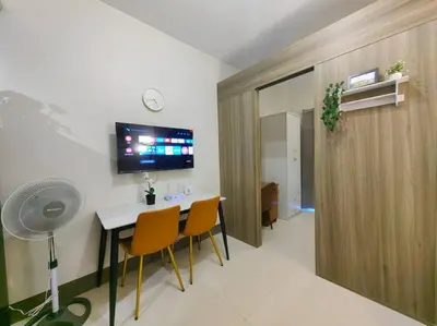 a room with a table and chairs and a fan at 1BR Condotel with Balcony at FAME Residences #FM47 in Manila