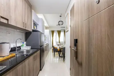 a kitchen with wooden cabinets and a dining room at Hotel style Unit 2924 Fame in Manila