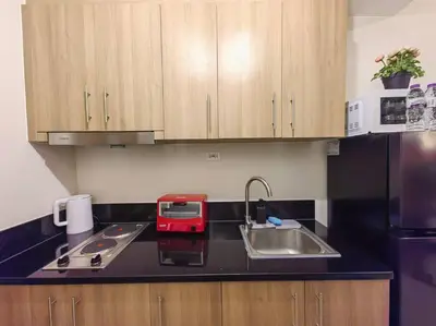 a kitchen with a sink and a red appliance on a counter at 1BR Condotel with Balcony at FAME Residences #FM51 in Manila