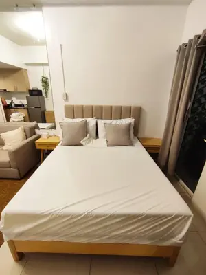 a large white bed in a room with a couch at Jinh's place to STAYCATION in Manila