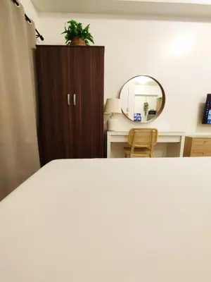 a bedroom with a bed and a mirror at Jinh's Abi staycations in Manila