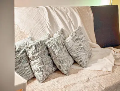 a group of pillows on a bed with a blanket at 823 Air Condo Shell Staycation Mall of Asia Walkable in Manila