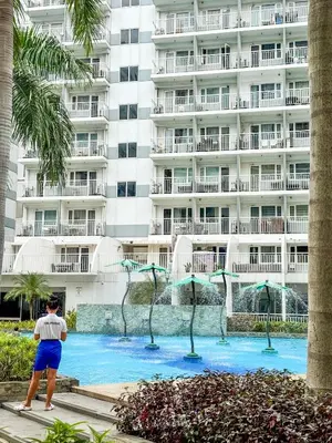 a man standing in front of a large building at 823 Air Condo Shell Staycation Mall of Asia Walkable in Manila