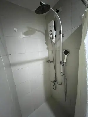 a bathroom with a shower with a shower head at Cozy 1 Bedroom Makati Condo with Balcony Wifi in Manila