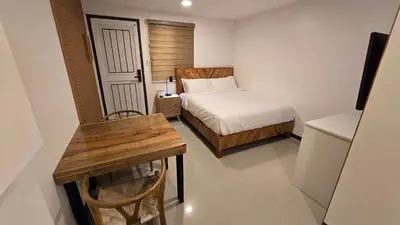 a small bedroom with a bed and a wooden table at Flat 35, Unit 1B in Manila