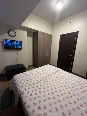 a bedroom with a bed and a clock on the wall at Park McKinley West unit 9Y Tower B in Manila