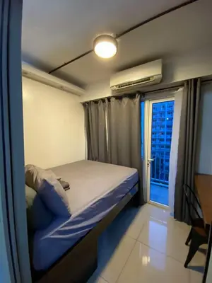 a small bedroom with a bed and a window at Industrial Design Bachelor's Pad with Pool View in Shore Residences in Manila