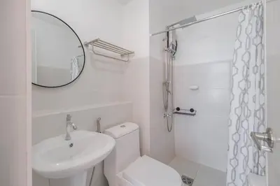 a bathroom with a toilet and a sink and a mirror at Japanese Stylish Condo in Makati in Manila