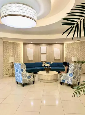 a lobby with a woman sitting in a waiting room at Near MOA Manila Bay Airport via NAIAX Balcony-Pool View WiFi SHELL Residences in Manila