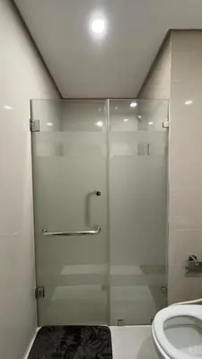 a glass shower in a bathroom with a toilet at New Cozy Condo in Eastwood in Manila