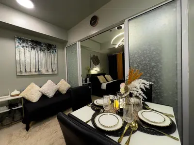 a room with a dining table and a living room at Oasis City Ventures in Manila