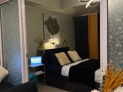 a bedroom with a bed and a mirror at Oasis City Ventures in Manila