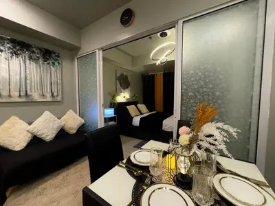 a room with a dining table and a living room at Oasis City Ventures in Manila