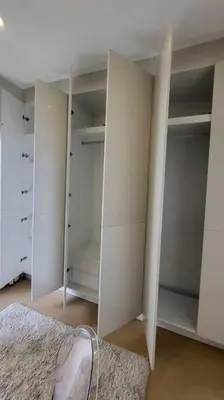 a closet with white cabinets and a shoe on a rug at 3BR Elegant & Central Loc- Netflix, WiFi, MiniBar! in Manila