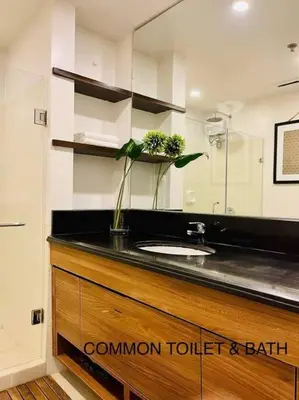 a bathroom with a counter with a sink and a mirror at 3BR Elegant & Central Loc- Netflix, WiFi, MiniBar! in Manila