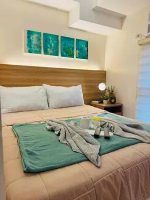 a bedroom with a bed with a blanket on it at Staycation in Mckinley walking distance to Venice Mall in Manila