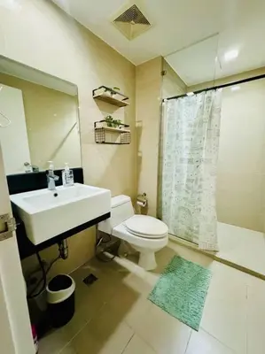 a bathroom with a sink and a toilet and a shower at Staycation in venice residences Mckinley with balcony in Manila