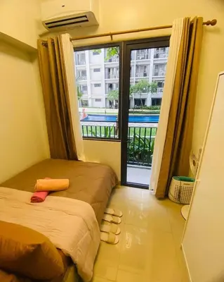 a bedroom with a bed and a large window at Shore 2 Residences Tuscia Home Staycation in Manila