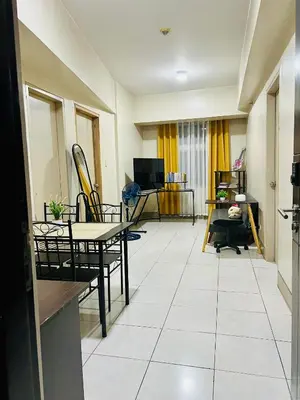 a living room with a table and chairs at 2 Bedroom condo unit in Manila