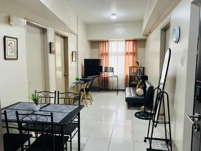 a living room with a table and chairs at 2 Bedroom condo unit in Manila