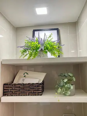 a shelf with a basket and flowers in a bathroom at Cozy place across Mitsukoshi Mall in Manila