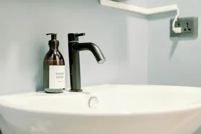 a bottle of wine sitting on top of a sink at Cozy and Spacious Studio at SOMA BGC Near SM Aura and Bonifacio High Street in Manila