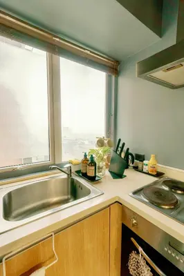 a kitchen with a sink and a window at Cozy and Spacious Studio at SOMA BGC Near SM Aura and Bonifacio High Street in Manila