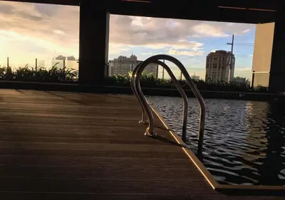 a metal chair sitting next to a body of water at The Cozy Corner in Manila