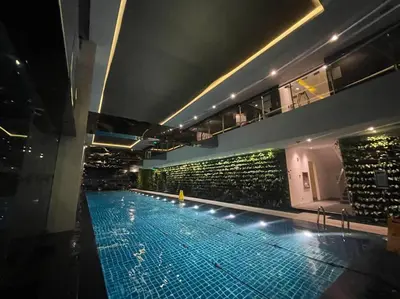 a large swimming pool in a building with a building at Spacious Unit in Gramercy Makati in Manila