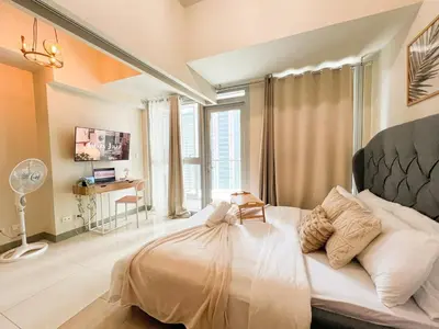 a bedroom with a large bed and a desk at Luxury BGC Condo Near Uptown,Grand Hyatt #upt219k in Manila