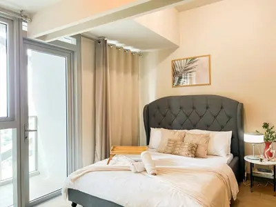 a bedroom with a large bed with a large window at Luxury BGC Condo Near Uptown,Grand Hyatt #upt219k in Manila