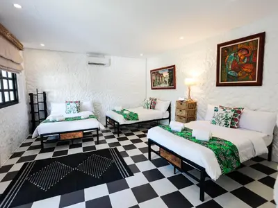 a living room with two beds and a checkered floor at Kasa Silang by Araw Residences in Cavite