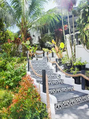 a row of black and white benches in a garden at Kasa Silang by Araw Residences in Cavite
