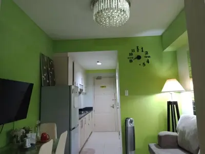 a kitchen with green walls and a refrigerator at Jericho's Place in Manila